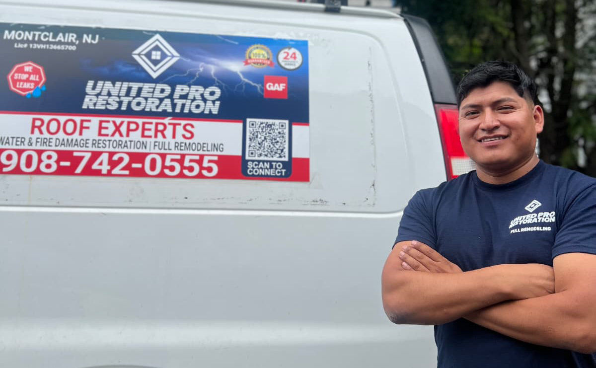 Jose Caguan, founder of United Pro Restoration, in front of one of his truck, with his logo.