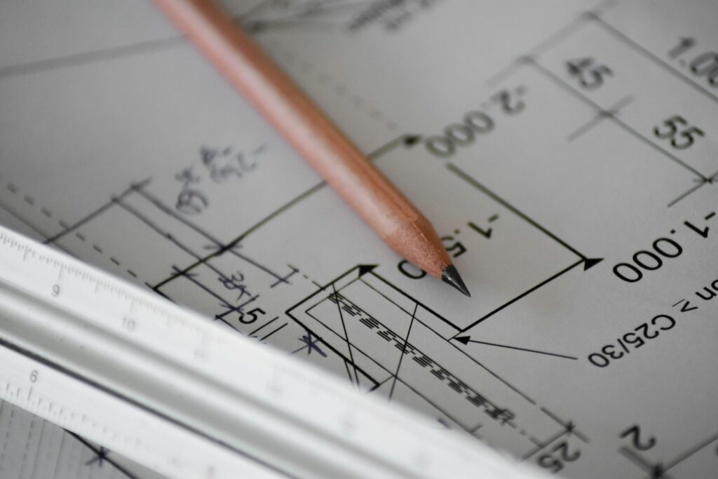 A close-up of a pencil resting on technical architectural drawings with measurement markings, numbers, and a white ruler—capturing the precision every roofing contractor in Lyndhurst brings to their planning.